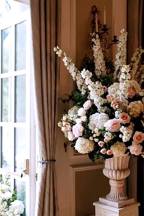 Tall cream and blush arrangement in a stone urn